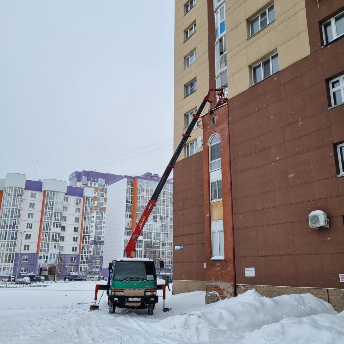 Разгрузка машины автокраном со стропальщиками